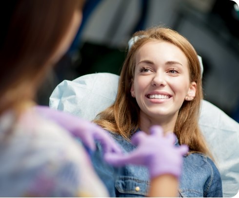 Patient talking with team member in dental chair